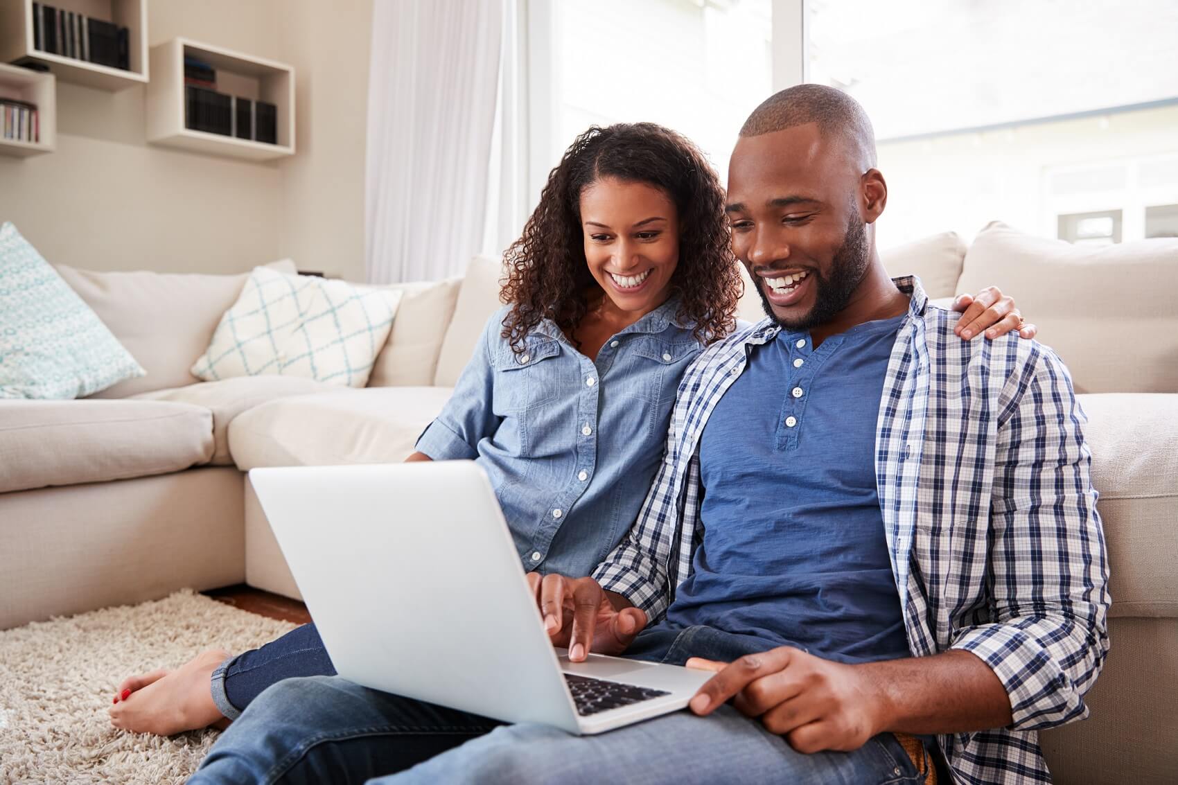 a smiling couple browse affordable chevy equinox lease options online at home