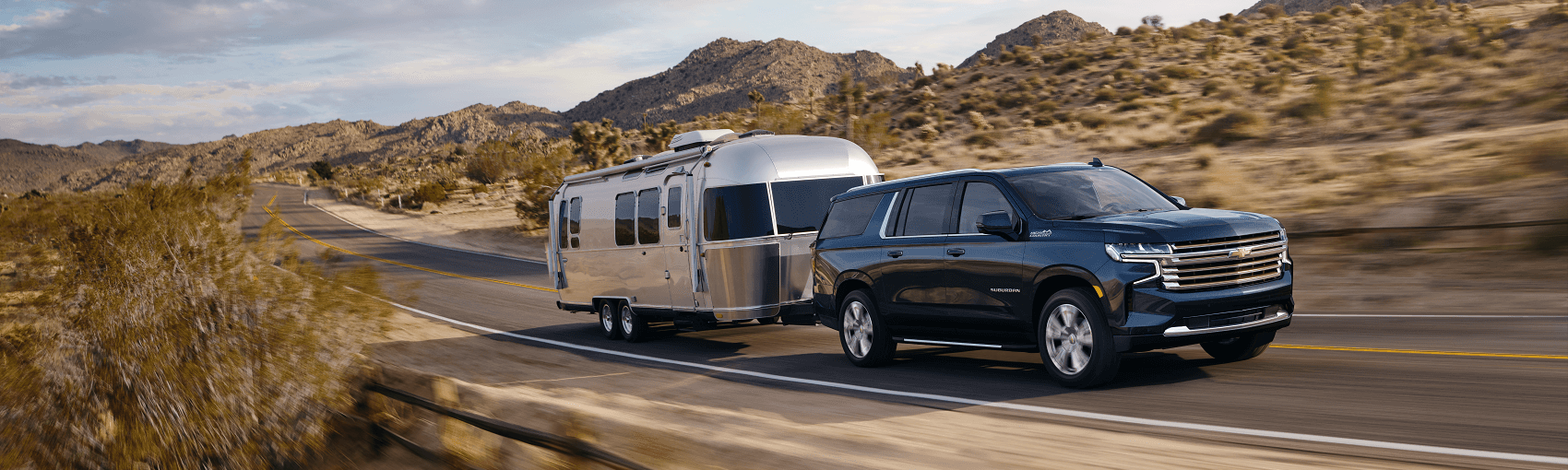 black chevy suburban towing airstream camper