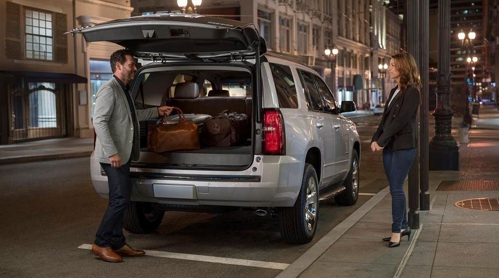 Man taking a bag out of the trunk while woman is watching | Feldman Chevrolet of Livonia in LIVONIA MI